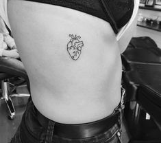 a woman's stomach with a heart tattoo on it