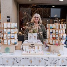 a woman standing in front of a table full of cards and boxes with flowers on them