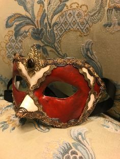 "Traditional and original papier-mache Venetian mask, handmade and decorated with acrylics colors, gold-leaf and trimming. This traditional Venetian mask shape is called \"Colombina\". All our masks are handmade papier-machè masks made in Venice. Our decorators use techniques typical of the Venetian tradition such as stucco, acrylics, gold and silver-leaf, macramè, passementerie, pearls and crequelè to give you a wide range of masks. This shape is available in many different designs, colors and Traditional Masquerade Mask For Carnival, Artistic Red Masks For Costume Party, Traditional Mardi Gras Masquerade Mask, Artistic Red Mask For Costume Party, Red Venetian Mask For Masquerade, Venetian Multicolor Masquerade Mask, Red Venetian Masquerade Mask, Venetian Masks For Mardi Gras, Venetian Masks For Mardi Gras Gift