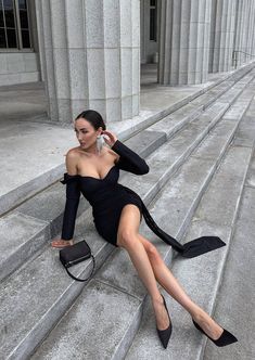 a woman in black dress sitting on steps