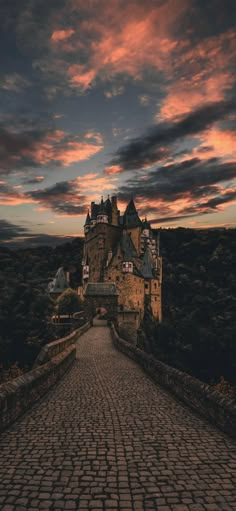 an image of a castle that is in the sky with clouds above it and cobblestone walkway leading up to it