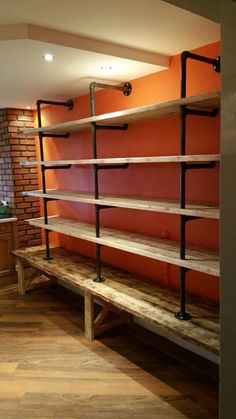 an empty room with some shelves on the wall and wood flooring in front of it