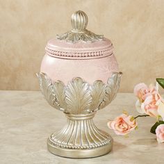 a pink vase sitting on top of a table next to flowers