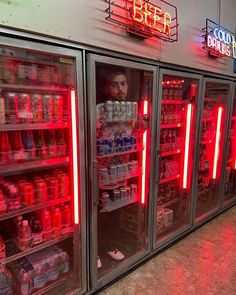 the coolers are filled with drinks and beverages for sale at the grocery store's neon sign