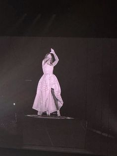 a woman standing on top of a stage wearing a white dress