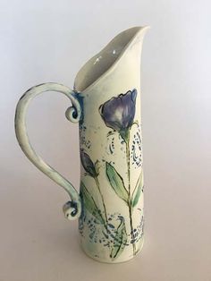 a white pitcher with blue flowers painted on it