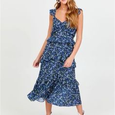 This Floral Maxi Dress Exudes Effortless Elegance And Feminine Charm. The Lightweight Fabric Drapes Beautifully, Making It Perfect For A Sunny Day Out. The Dress Features Adorable Flutter Sleeves, A Tied Open Back, And A Tiered Ruffle Skirt That Adds A Touch Of Whimsy And A Romantic Feel. Whether Pairing It With Sandals For A Casual Brunch Or Wearing Heels For An Outdoor Party, This Dress Will Turn Heads And Make A Statement. -Fit: Maxi -Closure: Slip On, Tied Back -Adjustable Straps -Sleeveless Flowy Maxi Dress For Day Out, Blue Dress With Ruffled Straps For Date Night, Brunch Midi Sundress With Ruffle Hem, Casual Midi Dress With Ruffled Skirt, Blue Floral Midi Dress For Day Out, Flowy Ruffled Midi Dress For Day Out, Flowy Blue Maxi Dress For Day Out, Sleeveless Dress With Ruffle Hem And Flowy Skirt, Spring Floral Dress With Ruffles For Date Night