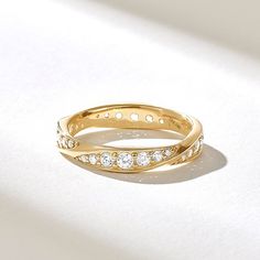 a yellow gold wedding band with small diamonds on the inside and outside, set against a white background