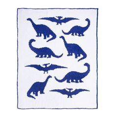 a blue and white knitted blanket with dinosaurs on it