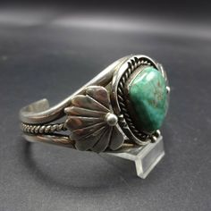 "VINTAGE NAVAJO BRACELET DESCRIPTION: This cuff features a gorgeous specimen of blue-green waterweb turquoise. The gemstone is secure in smooth bezel, on a foundation of heavy gauge vintage sterling silver. A thick twisted silver wire runs through the center of the split shank cuff. This bracelet will be a cherished addition to your collection of fine vintage Native American jewelry. MEASUREMENTS: Interior of the cuff measures 5 1/4\" with an additional 1\" slightly adjustable gap. Total circumf Classic Turquoise Adjustable Bracelet, Classic Adjustable Turquoise Cuff Bracelet, Adjustable Southwestern Green Cuff Bracelet, Adjustable Turquoise Bangle For Collectors, Southwestern Green Bangle Jewelry, Adjustable Green Southwestern Cuff Bracelet, Southwestern Style Green Bangle Jewelry, Jewelry Measurements, Bones Bracelet