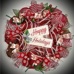 a red and white christmas wreath with a happy holidays sign on it