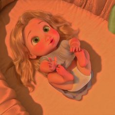 a baby doll laying on top of a bed