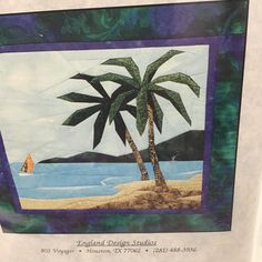 a quilted palm tree on the beach with a sailboat in the water behind it