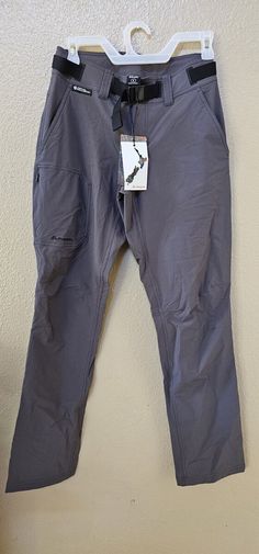 a pair of gray pants hanging on a wall