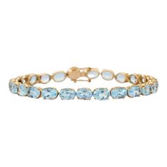 This is part of Chairish’s Fine Jewelry assortment.  This Sparkling Blue Topaz Tennis Bracelet in 18K gold showcases 25 endlessly sparkling natural blue topaz, weighing 28.5 carats. It measures 7.5 inches long in length.  Blue topaz helps to improve communication and self expression.  Designed with perfect oval cut blue topaz set in solid gold basket settings in repetition making a beautiful bracelet to make you stand out on any occasion or event. The elegant style complements the attire beautifully and this is a perfect Unique Gift, Bridal Shower Gift, Secret Santa Gift, Gift For Sister, Mother Daughter Gift, Bride To Be Gift, Bridesmaid Gift, Thanksgiving Gift, Anniversary Present, Christmas Gift or any Holiday Gift for Mother, Sister, Daughter, Grandma, Fiancé, Girlfriend, Valentine, Fa Elegant Gold Bracelets With Blue Topaz, Fine Jewelry Blue Topaz Bracelets, Elegant Gold Aquamarine Bracelet, Elegant Light Blue Aquamarine Bracelet, Yellow Gold Bracelet With Blue Topaz For Gifts, Yellow Gold Blue Topaz Bracelets Gift, Yellow Gold Bracelets With Blue Topaz For Gift, Formal Yellow Gold Bracelets With Blue Topaz, Luxury Blue Topaz Gemstone Bracelets