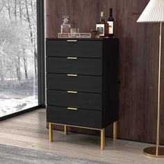 a black and gold chest of drawers next to a window with a lamp on it