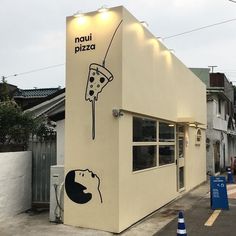 a building with a mural on the side of it that has a slice of pizza