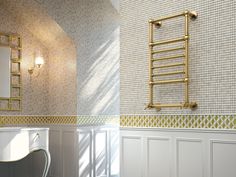 a bathroom with white walls and gold fixtures on the wall, along with a mirror