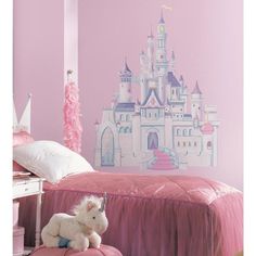 a bedroom decorated in pink and white with a princess castle mural