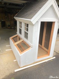 a dog house built into the side of a building with windows and sidings on it