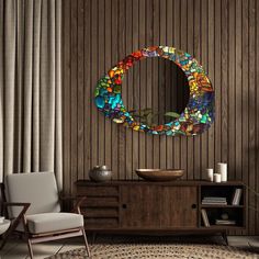 a round stained glass mirror on the wall above a wooden cabinet in a living room