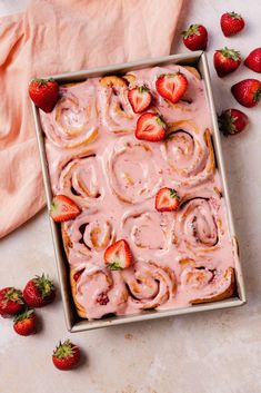 strawberry rolls with icing and strawberries in a pan