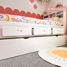 a child's bedroom with white drawers and pink walls