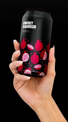 a woman's hand holding up a can of sweet squeezez with pomegranates on it