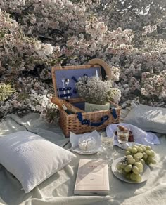 a picnic table with food, wine and flowers in the background on a sunny day