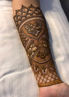 a woman's arm with henna tattoos on it