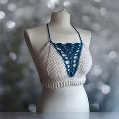 This one of a kind bralette will make you stand out wherever you go!  Featuring:  Deep V blue shell detailing! White ribbing around the waist! A criss cross back! Made in both white and turquoise 100% acrylic yarn.  Perfect for festivals with high waisted denim shorts or harem pants!  Bralette pictured is made to fit size medium and is ready to dispatch!  Full Sizing details:  Small - A-B cup  Medium - B-C cup Large - D cup  XL - DD cup Sizes vary depending on the coverage you want so if you are Festival Halter Neck Crop Top Bra Friendly, Handmade White Halter Top For Vacation, Festival Bra Friendly Cropped Top, Handmade White Crop Top For Summer, White Halter Neck Top For Festivals, Cropped Bra For Beach In Summer, Cropped Bra For Summer Beach, Summer Cropped Bra For Beach, Handmade White Crop Top For The Beach