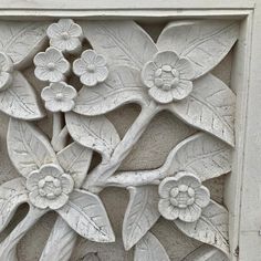 an intricately carved flower and leaf design on the side of a building