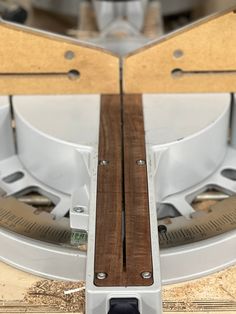 a close up view of the inside of a machine with wood and metal parts on it