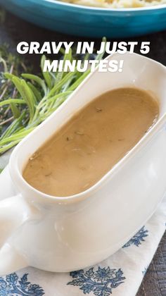 a white bowl filled with gravy sitting on top of a blue and white napkin