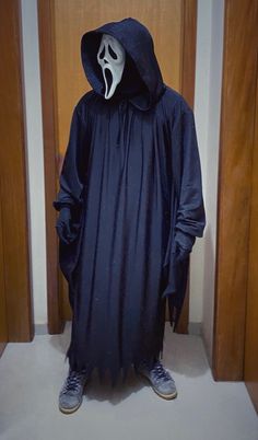 a person in a ghost costume standing next to two doors