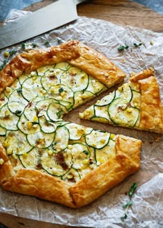 a pizza with zucchini and other toppings cut into slices