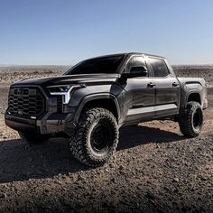 a black truck is parked in the desert