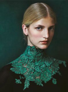 a woman with blonde hair wearing a black dress and green lace collared necktie