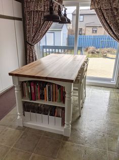 a kitchen island with bookshelves in front of a sliding glass door