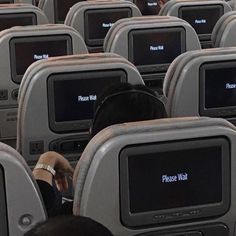 rows of empty seats in an airplane with the words please wall on their screen monitors