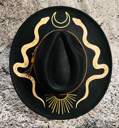 Welcome to Witchwood's brand new XL wide brim hats! These hats have our biggest brim yet! They are made of sturdy vegan felt and are all hand printed.   Vegan Felt Size: 23" (but size is adjustable and can be sized down, inside the hat) PLEASE NOTE: These hats have a bit more "give" to the circumference and can fit a slightly bigger size than our other wide brim hats Brim - 3.75" wide Hat Color - Black Print Color -Gold & Toffee or Silver & Grey Custom Wide Brim Felt Hat For Beach, Custom Wide Brim Festival Costume Hat, One-size Curved Brim Fedora For Festivals, Festival Fedora With Curved Brim, Black Wide Brim Panama Hat For Festivals, Curved Brim Fedora For Festivals, Wide Brim Costume Hats And Headpieces, Fitted Flat Brim Felt Hat For Festival, Black Bohemian Panama Hat With Curved Brim