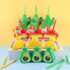 a group of plastic toys sitting on top of a white table next to green and yellow items