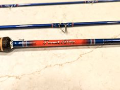 two different types of fishing rods sitting on a counter top next to each other,