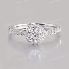 a white gold engagement ring with round diamonds on the band and side stones in the center