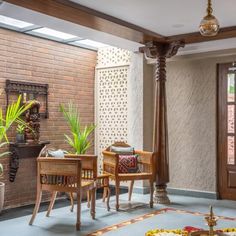 a living room filled with lots of furniture next to a brick wall and wooden doors