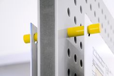 two yellow handles are attached to the side of a white and gray wall mounted device