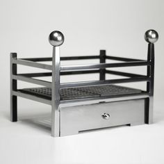 a metal object with two balls on it's sides and one drawer in the middle