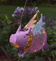 a pink pig hanging from a string with fairy lights on it