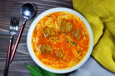 a bowl of soup with meatballs and noodles