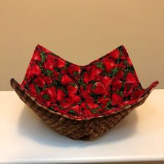 a basket with strawberries on it sitting on a table next to a white wall